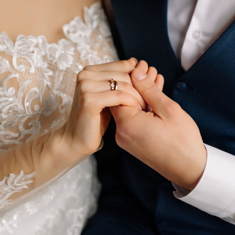 The groom holds the bride by the hand with ring. Beautiful elegant couple of newlyweds in love. Wedding concept. Close-up.