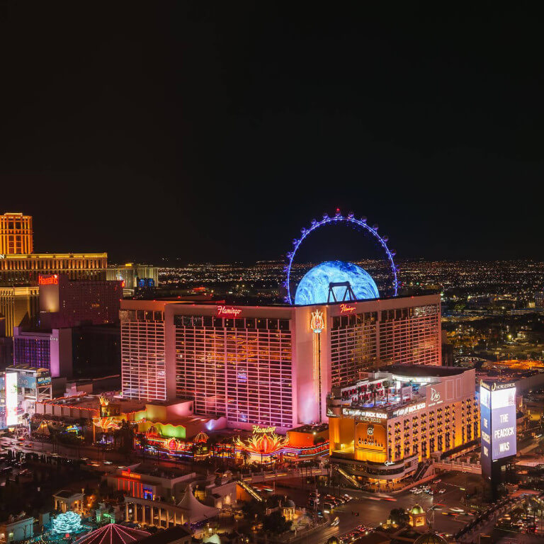 Vibrant aerial night view of las vegas strip observation wheel and neon lights at city center