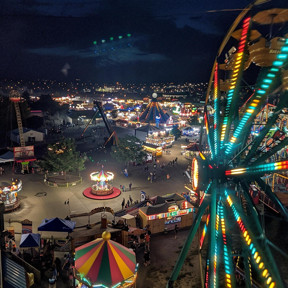 Photo realistic picture from a camera phone view shot of a overlooking a county fair from the point